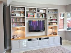 a living room filled with furniture and a flat screen tv on top of a wooden entertainment center