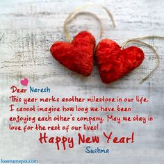 two red hearts hanging from strings with the words happy new year written below them on a white background