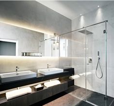 a bathroom with two sinks and a walk in shower next to a large mirror above the sink