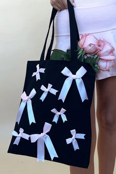 Bow covered canvas toteContent + CareDo not get wetAvoid contact with lotions and fragrances Small Business Ideas Clothing, Tod Bag Aesthetic, Tote Bag With Bow, Black Tote Bag Design Ideas, Canvas Bag Aesthetic, Coquette Closet, Aesthetic Tote Bag Design, Tote Bag Design Ideas, Diy Bags Jeans