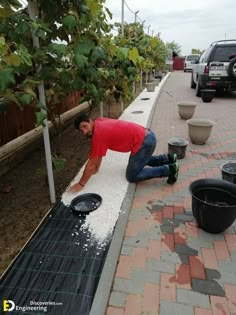 a man laying on top of a tarp next to two buckets filled with water