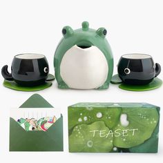 a frog tea set with two cups and a card holder, next to it's packaging