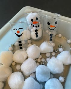 snowmen made out of cotton balls and plastic cups sitting on top of a tray