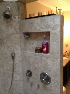 a bathroom with a walk in shower next to a sink and toilet paper dispenser