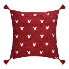 a red pillow with white mickey mouse heads on it and tassels around the edges