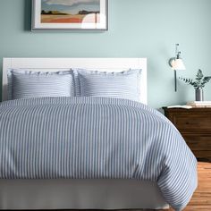 a bed with blue and white striped comforter in a bedroom