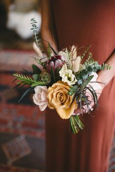 a woman holding a bouquet of flowers in her hands