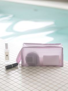 an electronic device sitting on top of a tiled floor next to a pool with a bottle