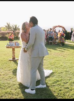 a bride and groom kissing in front of an outdoor ceremony