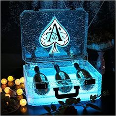 an ice box with four bottles of wine in it and some candles around the edges