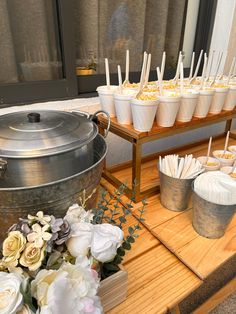 there are many cups on the table with sticks sticking out of them and some flowers