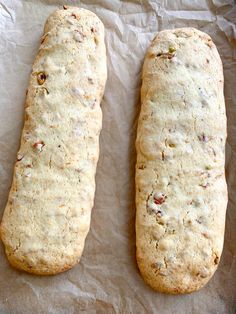 two breads sitting on top of a piece of wax paper next to each other