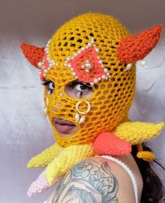 a woman wearing a yellow mask with horns on her head