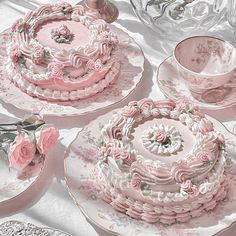 a table topped with pink and white plates covered in frosting