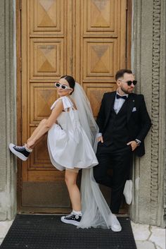 a man in a tuxedo standing next to a woman in a wedding dress