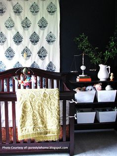 a baby crib in front of a black wall