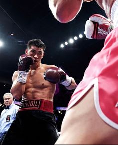 a man standing next to another man wearing boxing gloves