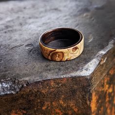 Olive Ash Burl overlaid on Smoked Oak.  Each ring is made to order. The ring in the image is an example of a finished product; due to natural variations in the timber, each ring is unique so please account for differences in pattern when you order. The Product: a handmade, one of a kind timber ring, crafted with love in Tassie. When you purchase a MBRB ring, you aren't just buying a piece of wood. Each ring is carefully made one at a time, and follows a lengthy and careful process.  The Process: MBRB rings are made using the Bentwood technique, making for a stronger ring than one simply cut from a piece of wood because the timber grain runs around the ring uninterrupted.  Thin strips of timber are cut or hand planed, then steamed and wrapped to form a ring. A strong adhesive forms a durabl Unique Carved Round Rings, Engraved Brown Ring Perfect For Gift, Unique Brown Rings For Gift, Handmade Round Wooden Jewelry, Handmade Brown Rings For Gift, Rustic Untreated Ring For Gift, Rustic Untreated Rings For Gift, Rustic Untreated Ring As A Gift, Natural Wood Jewelry With Natural Variations