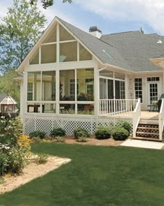 a white house sitting on top of a lush green field