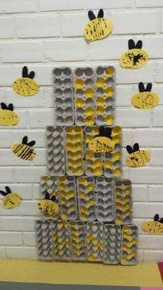 some yellow and black bees are on the wall with paper cut out to look like they are