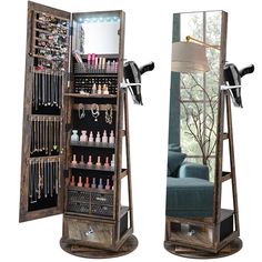 an open wooden jewelry cabinet next to a mirror with lights on it and a blue chair in the background