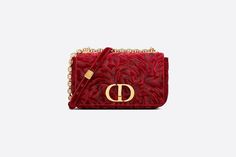 The Dior Caro bag combines modernity with timeless elegance. Inspired by a design form the House archives, it is fully embroidered with a red Dior Roses motif, made in matte cotton thread, accentuating the velvet's silky effect. The bag features a flap adorned with an antique gold-finish metal 'CD' twist clasp, inspired by the seal of a Christian Dior perfume bottle. The detachable chain shoulder strap with 'CD' signature links allows the meDiorried by hand or over the shoulder and may be replaced by one of the House's wide embroidered straps for day or evening attire. Flap closure with 'CD' twist clasp Embossed '30 MONTAIGNE' signature on the back Adjustable, removable 'CD' chain link strap with 'Christian Dior' military-inspired buckle Two removable links with an X-shaped center notch al Dior Caro Bag, Dior Perfume Bottle, Dior Caro, Christian Dior Perfume, Dior Perfume, Womens Designer Bags, Embroidered Velvet, Christian Dior Fashion, Military Inspired