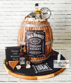 a birthday cake made to look like a barrel with whiskey and other items on it