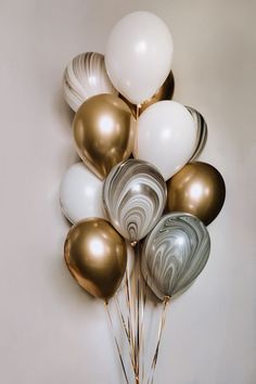 a bunch of balloons that are in the shape of marbles and swirls on a wall