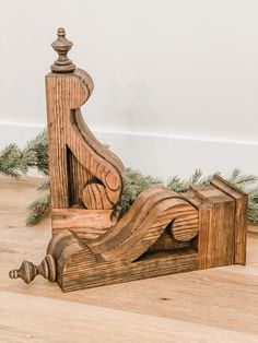 a wooden sculpture sitting on top of a hard wood floor next to a pine tree