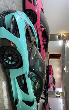 several different colored cars parked next to each other in a room with metal railings