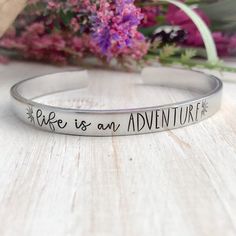 Life is an adventure. Made from 6" aluminum. These cuffs are lightweight and can easily be worn with other bracelets. Available in 3/8" and 1/2" widths.Custom orders and sayings welcome!Looking for something else? Check out my other listings!https://www.etsy.com/shop/StampinStitchin?ref=seller-platform-mcnavTO WEAR:Slide sideways over the thinnest part of your arm, and turn so the opening is at the bottom of your wrist. While these will bend a bit to fit a variety of wrists, once it is the corre Hand Stamped Cuff Bracelet, Mantra Bracelet, Boho Chic Bracelets, Metal Stamped Jewelry, Senior Gifts, Spoon Rings, Name Bracelet, Cute Bracelets, Stamped Jewelry