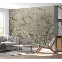 a living room scene with focus on the sofa and wallpaper that has flowers painted on it