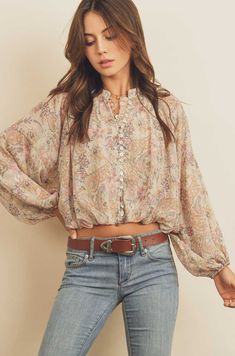 Light and airy and perfect to pair with gray denim or nude pencil skirt.  Paisley print semi-sheer top featuring button placket, balloon sleeves, and shirring detail at hem. Elasticized band at waist. Available in Small, Medium and Large Model is 5'8" and wearing size Small. Print Blouse Outfit, Skirt Poses, Types Of Prints, Baby Sitters Club, Paisley Print Design, Shirred Blouse, Floral Peasant Blouse, White Ruffle Blouse, Shirred Top