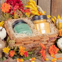 a basket filled with pumpkins and flowers next to a mason jar