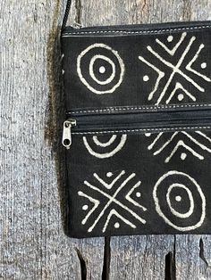 A beautiful Mudcloth and leather bag, perfect for small items like a passport, a phone, and small wallet. Made with genuine leather and authentic Mudcloth fabric from Mali.  Each bag is one is unique and one-of-a-kind.  Design may vary with each piece. 7.5" tall 6.5" wide Artisan Rectangular Bag With Zipper Pouch, Handmade Pouch Wallets For Travel, Handmade Black Wallets For Travel, Handmade Black Pouch For Everyday Use, Everyday Handmade Black Pouch, Artisan Black Pouch Bag, Black Rectangular Coin Purse With Zipper Pocket, Pouch With Zipper, Mudcloth Fabric