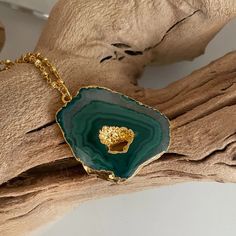 Looking for that "oomph" factor? Our 24k gold-dipped necklace, showcasing a dazzling green agate pendant, is your ticket to the glam express! This cheeky stunner turns heads and sparks conversations. From brunch with the girls to swanky soirées, this versatile piece is your new BFF. The green agate is all about balance and harmony, so you'll be oozing good vibes, darling! Act fast, fashionistas! Snag your Emerald Drop Necklace before it's poof gone! Features: 2" extender Lightweight Comfortable Gold Agate Crystal Necklace With Round Pendant, Gold Agate Round Pendant Crystal Necklace, Gold Agate Pendant Crystal Necklace, Gold Agate Jewelry With Large Pendant, Gold Agate Crystal Necklace For Gifts, Unique Gold Agate Necklaces, Unique Gold Agate Necklace, Gold Necklaces With May Birthstone Natural Stones, Gold Agate Necklace