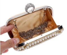 The AUBREE Clutch is a stylish and sophisticated accessory. With a pearl finish, this clutch offers a timeless beauty that will turn heads. With its sleek design, this clutch is the perfect accessory for any special occasion. Detachable Chain Included Approximate Size: 16.5 cm (L) x 4.5 cm (W) x 9.5 cm (H) Luxury Pearl Clutch For Party, Gold Pearl Evening Bag For Events, Chic Pearl Clutch For Party, Gold Pearl Clutch For Parties, Formal Gold Clutch With Pearl Material, Chic Pearl Clutch For Formal Occasions, Glamorous Pearl Clutch For Formal Occasions, Glamorous Pearl Clutch For Formal Events, Chic Pearl-embellished Clutch For Formal Occasions