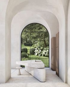 a white bench sitting under an arched window