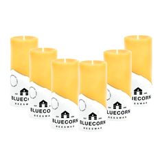 four yellow candles sitting next to each other on top of a white surface with the words bluecorn written in black