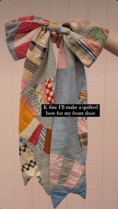 a person holding up a scarf with words on it that say, k fine i'll make a quilted bow for my front door