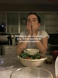 a woman sitting at a table with her hands over her face and food in front of her