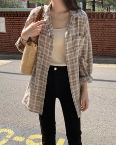 a woman standing on the street with her hand in her pocket