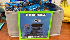 a basket filled with cookies and candy sitting on top of a table next to bananas