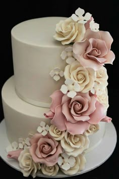 a three tiered cake with pink and white flowers on top