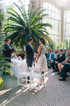 a man and woman standing next to each other in front of a group of people