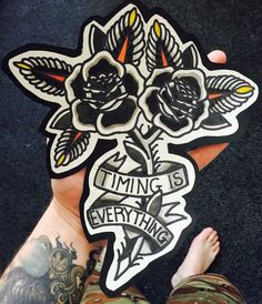 a person holding up a sticker with flowers on it that says, time is everything