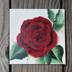 a painting of a red rose with green leaves