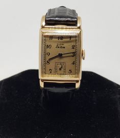 1939 Gold Filled Elgin De Luxe Wrist Watch, Grade 537, Size 15/0s, 17 Jewels, Needs Work. Balance wheel spins freely, crown won't wind. Movement with, Elgin-U.S.A., X95413, 17 Jewels. Inside back of case with, Cased and timed by Elgin National Watch Co., 10K Gold Filled, Lutringer and Wittmer, 4579. Back of case with, 10K Gold Filled, L&W. Dial shows some scratches to paint. Crystal with a few small scratches. Case with some scratches. Spiedel band looks great. Watch and band are 8 7/8", pins are 15mm. We do not test items to see how long or how accurate they run. All items we sell have had a previous owner(s). None, and I'll repeat it, none of our watches online are currently serviced unless they state so in the description. To get a watch overhauled (timing etcetera) it costs 3-400+ not Antique Gold Rectangular Watch Accessories, Vintage Collectible Watch With Rectangular Dial, Metal Watch With Polished Finish, Rectangular Dial, Work Balance, Wind Movement, Balance Wheel, Antique Self-winding Yellow Gold Watch, Classic Self-winding Collectible Watch, Star Sapphire