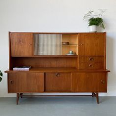 a wooden cabinet with drawers and a potted plant sitting on it's side