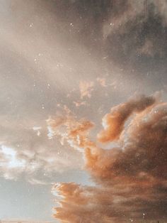 an airplane flying in the sky with clouds and stars above it at sunset or sunrise